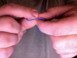 Magician touches thumbs to forefingers in the elastic band