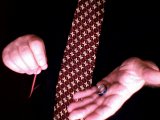 magician holds elastic band and a ring