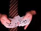 magician thumbs through the cards