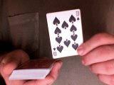 magician holds up the 10 of spades