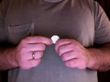 Magician places coin between his thumb and forefinger