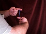 Magician rotates fingers inside the elastic band
