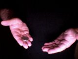 Magician holds coin on his right fingers