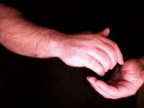 magician conceals coin in right hand