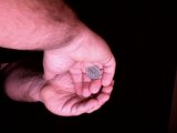 Magician shows how coin is concealed