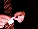 magician folds right side of paper over coin