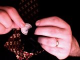 magician hides coin in his tie