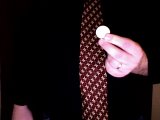 magician holds new coin in left hand