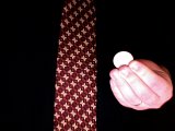 magician pinches a coin between his fingers