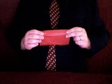 magician holds up cigarette paper